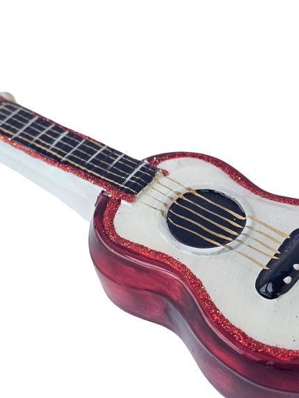 Gitara – stiklinio žaisliuko detalė iš šono: rezonansinė anga, auksinės stygos ir raudonas kraštas su blizgučiais